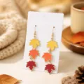 Close-up detail of gradient autumn maple leaf earrings in yellow, orange and red. - Yellow Orange Dark Red Gradient Maple Leaf (25080613-1)