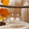 Close-up of elegant autumn maple leaf dangle earrings with white pearl and gold hooks. - White Maple Leaf Artificial Pearl Style (25080611-3)