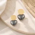 Close-up shot of retro geometric gold-tone disc and textured dark grey heart dangle earrings. - Heart Style (26080505-4)