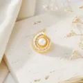 Close-up detail of the vintage gold spiral shell pearl cufflink on textured stone background. - Gold Conch Pearl (26080501-4)