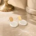 Close-up detail view of elegant French style textured white disc earrings with chic gold studs. - Round Plate Shape (26080503) / Gold