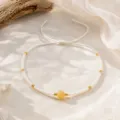 Gros plan détaillé d'un bracelet cordon réglable fait main style bohème avec perles. - Blanc