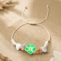 Gros plan détail du beau bracelet cordon tressé fait main avec une fleur en argile verte. - Fleur en Céramique Souple Verte et Blanche