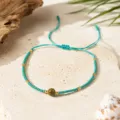 Détail de bracelet réglable en perles bohèmes, centre en pierre avec détails dorés. - Bleu-vert