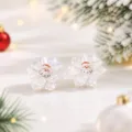 Nahaufnahme von weißen Harzblumen-Ohrsteckern mit süßem Weihnachtsmann-Detail im Zentrum. - Weißer Weihnachtsmann