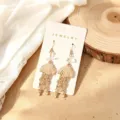 Élégantes boucles d'oreilles pendantes méduse dorées ornées de perles et de cristaux fins. - Méduse / Or