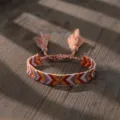 Etnische geweven stoffen armband met kleurrijk chevronpatroon en verstelbaar kwastdesign. - 22112527