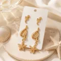 Vue détaillée de la parure de boucles d'oreilles dorées de style marin avec des clous et coquillages. - Ensemble 5