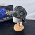 Detailed view of vintage camo denim bucket hat featuring rolled brim and metallic side buttons. - M (56-58cm) / Camo Army Green