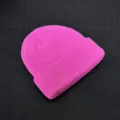 Bright pink knitted beanie close-up, ribbed texture winter skull cap detail display. - One Size / Rose Red