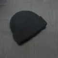 Primo piano dettagliato di un berretto in maglia nera, che mostra la sua trama fine. - Taglia unica / Nero