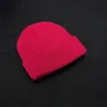 Detailed shot of a bright pink cuffed knit beanie, soft texture and cozy winter accessory. - One Size / Red