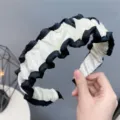 Detail shot of black and white velvet ruffle headband showing soft fabric texture and unique design. - Beige