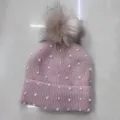 Primer plano detalle del gorro de punto rosa con perlas blancas y pompón esponjoso. - Talla única / Gorro de Punto Adornado con Cuentas - Rosa