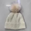 Detailed view of women winter knit beanie hat featuring pearl decor and fluffy fur pom. - One Size / Bead-Embellished Knit Beanie - Beige