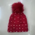 Detail shot of a winter warm red knit beanie hat featuring faux pearl studs and a fluffy pom pom. - One Size / Bead-Embellished Knit Beanie - Red