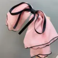 Detail view of a sweet pink chiffon double bow hair clip with black edge and ribbons. - Pink