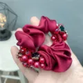 Wine red satin hair scrunchie detail featuring pearls, crystals and black flower charms. - Burgundy