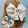 Large satin bow hair clip in elegant champagne color, featuring a secure metal spring barrette. - Spring Clips / Beige