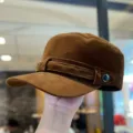 Close-up detail of a brown corduroy flat top hat featuring side decorative strap and metal button. - M (56-58cm) / Brown