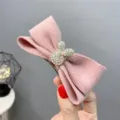 Detail view of pink knit bow hair clip with rhinestone rabbit accessory for autumn winter. - Bow Rhinestone Rabbit / Pink