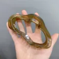 Detail view of the jelly brown acrylic cloud hair claw clip, stylish and transparent design. - Olive Green