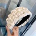Gros plan sur un serre-tête large en cuir PU tressé avec un style bicolore noir et blanc. - Série Blanc Lait