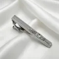 Gros plan détaillé d'une pince à cravate argentée avec strass scintillants sur satin blanc. - Argent Avec Zircone