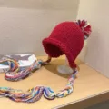 Detalle de gorro de punto rojo con borlas trenzadas coloridas y pompón esponjoso. - M (56-58cm) / Rojo