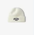Primer plano de un gorro de punto acanalado blanco con detalle bordado de Nueva York. - Talla Única Elástica / Crema