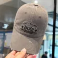 Detalle de gorra de béisbol gris deslavada con bordado ENJOY y diseño con roturas. - M (56-58cm) / Gris
