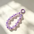 Purple beaded phone strap detail shot showing frosted and glossy beads with a round clasp. - Purple