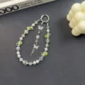 Detailed close-up view of a luxury crystal butterfly phone chain and bag charm accessory. - White