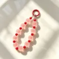 Dettaglio affascinante di ciondolo per telefono con perline rosa e rosse, accessorio chic. - Rosso