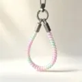 Close-up detail of colorful telephone wire TPU wrist phone strap with silver metal clasp. - Rainbow Gradient Green