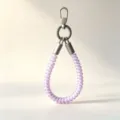 Detail view of the colorful TPU telephone wire wrist lanyard for phone case, sturdy design. - Purple Musical Note