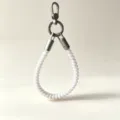 Detailed view of white telephone wire phone charm strap with sturdy metal clasp and hook. - White Musical Note