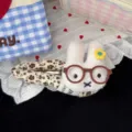 Cute plush rabbit hair clip with floral fabric wrap and round glasses detail, soft accessory. - Beige