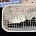 Close-up view of a stylish black and white pleated polka dot hair clip inside a white basket. - Pleated Teardrop Hair Clip / White