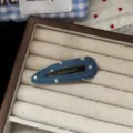 Detailed close-up shot of a cute blue denim hair clip featuring shimmering silver star prints. - Hollow Waterdrop Hair Clip
