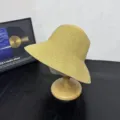 Detailed view of the stylish yellow straw sun hat on wooden stand, ideal for outdoor beach. - M (56-58cm) / Solid Style / Floral Khaki