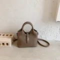 Brown leather bucket bag with top handle and stylish clasp closure, compact commuter handbag. - No Pendant / Khaki