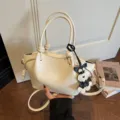 Sac à main blanc minimaliste avec poignées nouées et charm pour femme style mode printanière. - Blanc Avec Pendentif