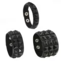 Detailed close-up of black punk leather bracelets featuring square metal studs and snap closures. - Single Row / Black
