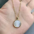 Close-up view of gold Guadalupe necklace with natural mother-of-pearl round pendant detail. - Guadalupe
