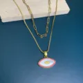 Double layer gold necklace featuring a mother of pearl evil eye pendant with pink cubic zirconia. - Red