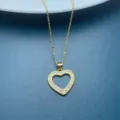 Gold heart pendant necklace detail showing sparkling cubic zirconia stones clearly and elegantly. - White