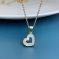 Close-up detail of the elegant natural white mother-of-pearl hollow heart pendant necklace. - Gold