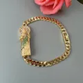 Gold-tone Cuban link bracelet featuring a detailed saint pendant with cubic zirconia. - Green