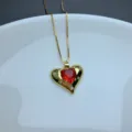 Gold chain necklace featuring a red heart pendant with micro-set rhinestones, detailed view. - Style E